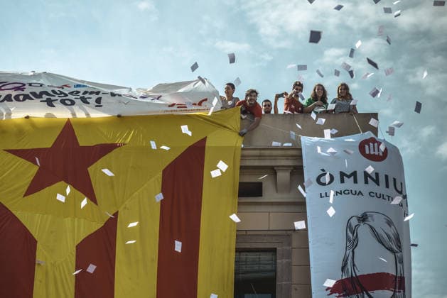 September 24, 2017 - Barcelona, Catalonia, Spain - Pro-independence activists hang a giant Estelada flag from the top of a building and throw ballot papers during the performance of the Castellers (human towers) during Barcelona s city festival La Merce in support of the planned secession referendum at October1st. Spain s constitutional court has suspended the Catalan referendum law after the Central Government has challenged it in the Courts Copyright: xMatthiasxOesterlex