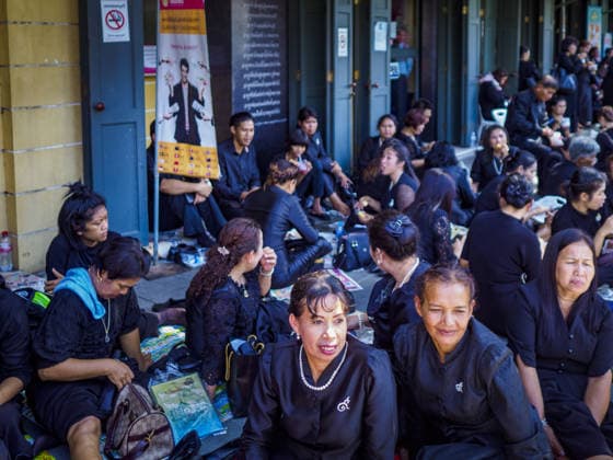 September 27, 2017 - Bangkok, Bangkok, Thailand - Thais sit on a sidewalk across the state from the Grand Palace after paying respects to the funeral urn of the late King, Bhumibol Adulyadej. The King died on October 13, 2016. Thailand has been in a state of mourning since. He will be cremated on October 26, 2017. Thais have been going to the Grand Palace to pay respects to the revered King. The Thai government has announced that the palace will close to the public on October 4, 2017, to prepare for the Monarch s funeral. Since the announcement, tens of thousands of Thais have lined up at the palace every day to pay their final respects. Copyright: xSeanxEdisonx