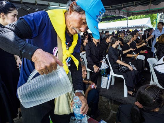 September 27, 2017 - Bangkok, Bangkok, Thailand - A volunteer pours cold drinking water into a bottle for a person waiting to pay final respects to the funeral urn of the late King. Bhumibol Adulyadej, the Late King of Thailand, died on October 13, 2016. Thailand has been in a state of mourning since. He will be cremated on October 26, 2017. Thais have been going to the Grand Palace to pay respects to the revered King. The Thai government has announced that the palace will close to the public on October 4, 2017, to prepare for the Monarch s funeral. Since the announcement, tens of thousands of Thais have lined up at the palace every day to pay their final respects. Copyright: xSeanxEdisonx