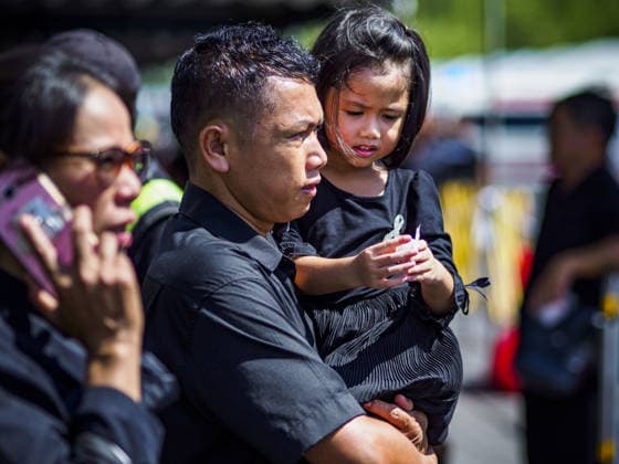 September 27, 2017 - Bangkok, Bangkok, Thailand - A man carries his daughter to the Grand Palace on their way to pay final respects to the funeral urn of the Late King. Bhumibol Adulyadej, the Late King of Thailand, died on October 13, 2016. Thailand has been in a state of mourning since. He will be cremated on October 26, 2017. Thais have been going to the Grand Palace to pay respects to the revered King. The Thai government has announced that the palace will close to the public on October 4, 2017, to prepare for the Monarch s funeral. Since the announcement, tens of thousands of Thais have lined up at the palace every day to pay their final respects. Copyright: xSeanxEdisonx
