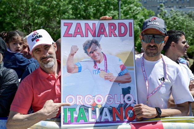 May 12, 2026, Catanzaro, Catanzaro, Italy: Spectators at the park. The fourth stage of the 2026 Giro d Italia, the first in Italy, started from the Mediterranean Biodiversity Park in Catanzaro and headed toward Cosenza, covering 138 kilometers. Pictured is a poster commemorating Zanardi. Catanzaro, May 12, 2026 Giro D Italia. Departure From Catanzaro  - ZUMAa289 20260512_zia_a289_054 Copyright: xValeriaxFerrarox xAgfx