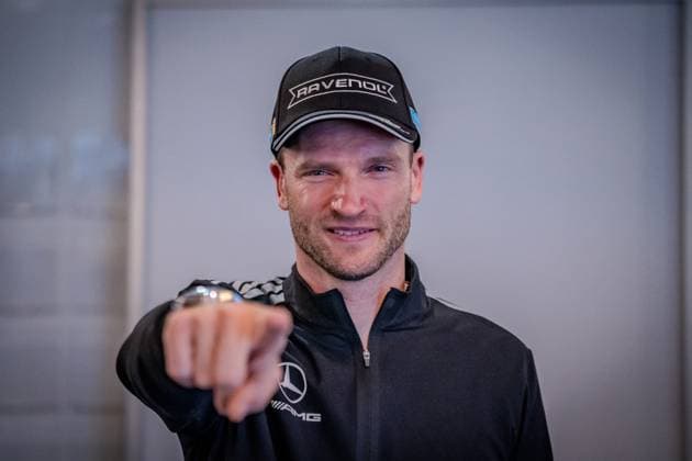 Maro Engel, driver of the Mercedes AMG Team RAVENOL 80 , smiling and pointing his finger towards the camera He is wearing a black RAVENOL cap and a black Mercedes AMG jacket The portrait was taken in the paddock of the Nürburgring on the occasion of the ADAC RAVENOL 24h Nürburgring 2026 Maro Engel points into the camera at the 24h Nürburgring 2026 Copyright: xspeedshotx
