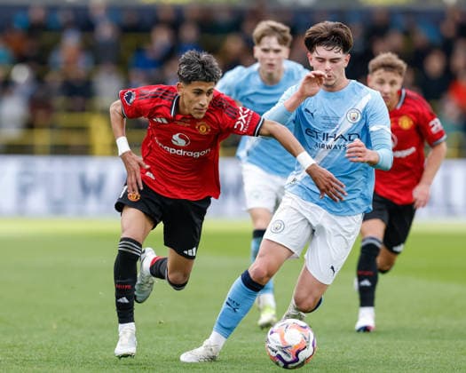 Manchester, England, 14th May 2026. Joseph Junior Andreou Gabriel (JJ Gabriel) of Manchester United, ManU breaks past Harrison Miles of Manchester City during the Manchester City U18 vs Manchester United U18 FA Youth Cup Final match at the Academy Stadium, Manchester. Picture credit should read: Cody Froggatt Sportimage EDITORIAL USE ONLY. No use with unauthorised audio, video, data, fixture lists, club league logos or live services. Online in-match use limited to 120 images, no video emulation. No use in betting, games or single club league player publications. SPI_020_CF_MANCHESTER_CITY_U18_V_MANCHESTER_UNITED_U18 SPI-4801-0018