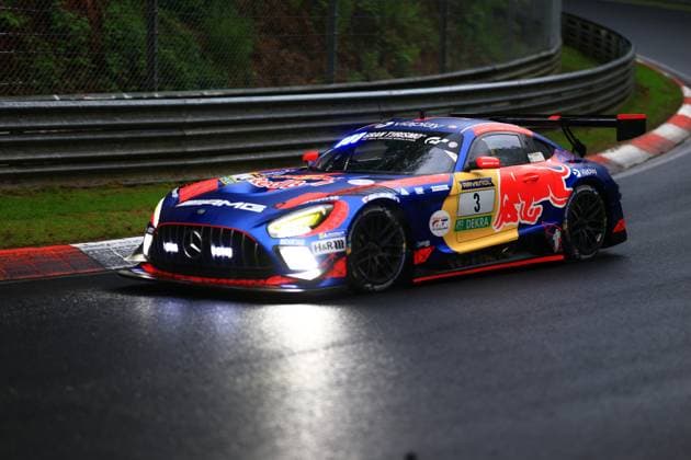 The Mercedes AMG GT3 with starting number 3 of the Mercedes AMG Team Verstappen Racing drives through a corner on the Nordschleife of the Nürburgring on a wet track The vehicle Daniel Juncadella Jules Gounon Lucas Auer Max Verstappen Mercedes AMG Team Verstappen Racing wears an eye-catching livery in the Red Bull colors blue, Red and yellow with the distinctive Red Bull logo on the side of the vehicle Other sponsors such as RAVENOL, Gran Turismo, Viaplay, H R and DEKRA can be seen on the AMG GT3 The switched-on headlights and the wetness of the asphalt underline the demanding conditions on the legendary race track in the Eifel Mercedes AMG GT3 3 from Verstappen Racing on the Nordschleife Copyright: xspeedshotx