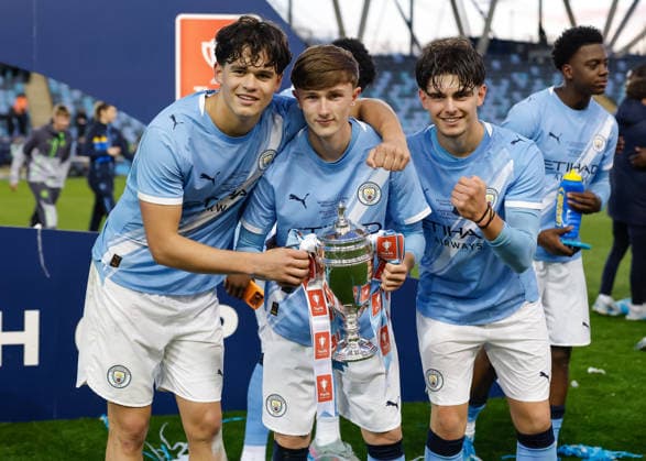 Manchester, England, 14th May 2026. Left to right, Teddie Lamb, Finlay Gorman and Harrison Miles of Manchester City pose for a photo with the FA Youth Cup trophy following the Manchester City U18 vs Manchester United, ManU U18 FA Youth Cup Final match at the Academy Stadium, Manchester. Picture credit should read: Cody Froggatt Sportimage EDITORIAL USE ONLY. No use with unauthorised audio, video, data, fixture lists, club league logos or live services. Online in-match use limited to 120 images, no video emulation. No use in betting, games or single club league player publications. SPI_077_CF_MANCHESTER_CITY_U18_V_MANCHESTER_UNITED_U18 SPI-4801-0075