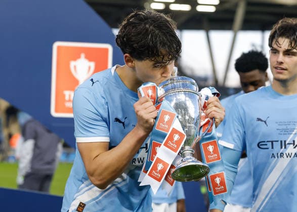 Manchester, England, 14th May 2026. Teddie Lamb of Manchester City kisses the FA Youth Cup trophy as he celebrates following the Manchester City U18 vs Manchester United, ManU U18 FA Youth Cup Final match at the Academy Stadium, Manchester. Picture credit should read: Cody Froggatt Sportimage EDITORIAL USE ONLY. No use with unauthorised audio, video, data, fixture lists, club league logos or live services. Online in-match use limited to 120 images, no video emulation. No use in betting, games or single club league player publications. SPI_078_CF_MANCHESTER_CITY_U18_V_MANCHESTER_UNITED_U18 SPI-4801-0076