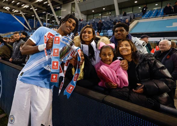 Manchester, England, 14th May 2026. Reigan Heskey of Manchester City celebrates with the FA Youth Cup trophy with his family following the Manchester City U18 vs Manchester United, ManU U18 FA Youth Cup Final match at the Academy Stadium, Manchester. Picture credit should read: Cody Froggatt Sportimage EDITORIAL USE ONLY. No use with unauthorised audio, video, data, fixture lists, club league logos or live services. Online in-match use limited to 120 images, no video emulation. No use in betting, games or single club league player publications. SPI_091_CF_MANCHESTER_CITY_U18_V_MANCHESTER_UNITED_U18 SPI-4801-0089