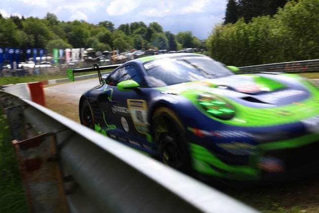 A Porsche 911 GT3 in the distinctive dark blue and green livery of the Reiter Engineering Team passes a crash barrier on the Nordschleife of the Nürburgring at high speed The vehicle racing car bears the starting number 91 and shows the typical color scheme of the team with striking green accents The motion blur underlines the high speed of the vehicle at the ADAC RAVENOL 24h Nürburgring 2026 Porsche GT3 in dark green livery at the crash barrier at the Nürburgring Copyright: xMichaelxGelhardtx