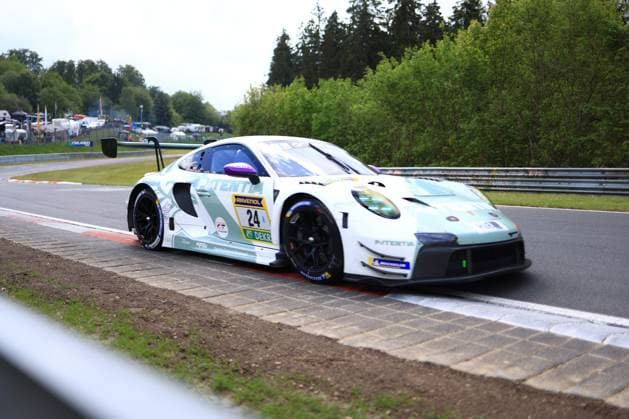 The Porsche 911 GT3 R with starting number 24 from Lionspeed GP negotiates a bend on the Nürburgring The vehicle Laurens Vanthoor Laurin Heinrich Ricardo Feller Lionspeed GP is presented in a striking white livery with mint green accents and the main sponsor Patentia The photo shows the vehicle on the characteristic red and white curbs of the track, with crash barriers and the tree-lined surroundings of the Eifel track visible in the background Porsche 911 GT3 R 24 from Lionspeed GP on the Nürburgring Copyright: xMichaelxGelhardtx