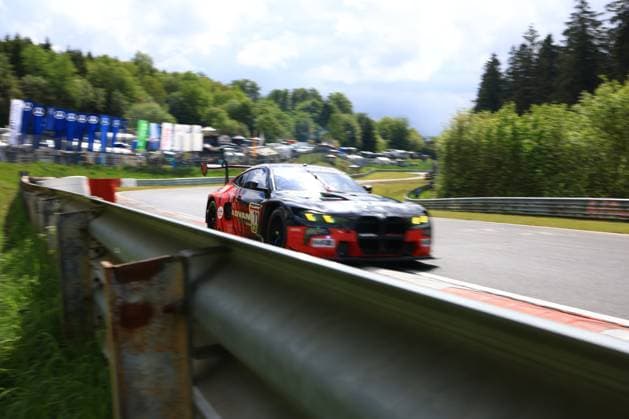 The Giuliano Alesi Kazuto Kotaka Miki Koyama Shunji Okumoto Toyo Tires with Ring Racing from Toyo Tires with Ring Racing drives at high speed through a corner on the Nordschleife at the Nürburgring The BMW M4 GT3 shows a striking black and red livery with ADVAN sponsorship The characteristic green hills of the Eifel and the paddock can be seen in the background The vehicle is framed by a crash barrier in the foreground, which emphasizes the dangerous proximity to the track boundary BMW M4 GT3 170 from Toyo Tires with Ring Racing on the Nordschleife Copyright: xMichaelxGelhardtx