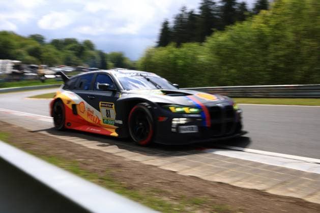 The Jens Klingmann Ugo de Wilde Schubert Motorsport from Schubert Motorsport drives through a bend on the Nürburgring at high speed The BMW M4 GT3 wears a striking black, yellow and red livery with Shell Helix and RAVENOL sponsoring as well as the characteristic BMW colors blue and red as accent stripes The green headlights and red brake calipers give the car a striking look The panning shot underlines the dynamics of the car at the ADAC RAVENOL 24h Nürburgring. red as accent stripes The green headlights and the red brake calipers give the car a striking look The panning shot emphasizes the dynamics of the car at the ADAC RAVENOL 24h Nürburgring 2026 BMW M4 GT3 81 by Schubert Motorsport at the Nürburgring Copyright: xMichaelxGelhardtx