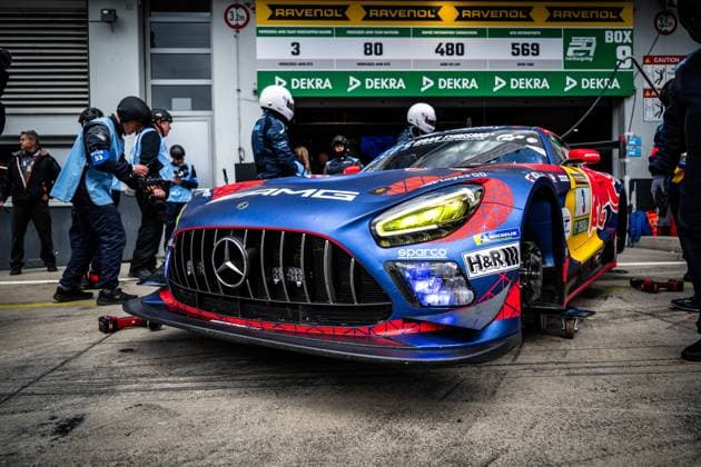 The Mercedes AMG GT3 with the starting number 3 of the Mercedes AMG Team Verstappen Racing is parked in the pit lane at the Nürburgring The vehicle in striking blue, red and yellow Red Bull livery with AMG, Sparco and H R sponsorship is looked after by mechanics in light blue team uniforms The pit board with the starting numbers 3, 80, 480 and 569 as well as RAVENOL and DEKRA advertising banners are visible Daniel Juncadella Jules Gounon Lucas Auer Max Verstappen Mercedes AMG Team Verstappen Racing Mercedes AMG GT3 3 from Verstappen Racing in the pits at the Nürburgring Copyright: xMichaelxGelhardtx