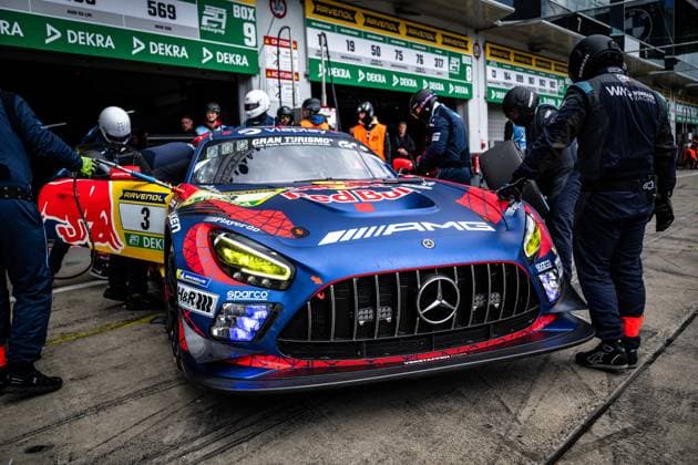 The Mercedes AMG GT3 with starting number 3 of the Mercedes AMG Team Verstappen Racing is ready for a pit stop in the pit lane of the Nürburgring The striking blue and red car bears the sponsors Red Bull, AMG, Gran Turismo, Sparco and H R and is equipped with yellow headlights Several mechanics are concentrating on the Daniel Juncadella Jules Gounon Lucas Auer Max Verstappen Mercedes AMG Team Verstappen Racing , while other cars and pits of the competition can be seen in the background The pit lane scoreboard as well as DEKRA and RAVENOL advertising banners characterize the scenery of the 24h Nürburgring Mercedes AMG GT3 3 of Verstappen Racing during the pit stop at the Nürburgring Copyright: xMichaelxGelhardtx