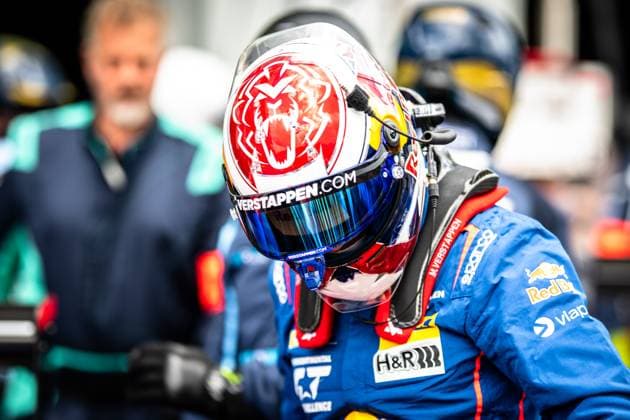 A driver of the Mercedes AMG Team Verstappen Racing stands in the paddock at the Nürburgring The distinctive helmet with the lion motif and the Verstappen com lettering is just as clearly recognizable as the blue racing overall with the sponsors Red Bull, H R and Sparco The name M Verstappen can be read on the overall In the background, other team members in turquoise jackets can be seen out of focus Max Verstappen in the paddock at the 24h Nürburgring 2026 Copyright: xMichaelxGelhardtx