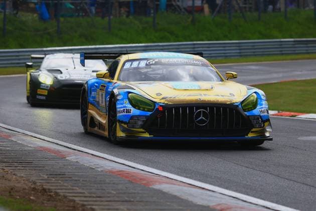 The Mercedes AMG GT3 with starting number 26 from PROsport Racing negotiates a corner at the Nürburgring in wet track conditions The vehicle in the characteristic blue and yellow pixel design with AMG , H R and Goodyear sponsorship leads the field, while another vehicle follows in the background Adam Christodoulou Christopher Lulham Marek Böckmann Mikaël Grenier PROsport Racing Mercedes AMG GT3 26 from PROsport Racing at the Nürburgring Copyright: xspeedshotx