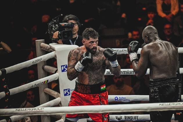 Intense boxing match between Senad Gashi 120 and Peter Kadiru 129 at the SAP Arena Mannheim on 15 05 2026 The tattooed boxer in red shorts leads offensively while his opponent reacts in a defensive stance A cameraman documents the ringside action of the heavyweight fight Ringside, 15 05 2026, Mannheim, SAP Arena Copyright: xspeedshotx