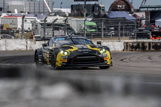 The black and yellow Aston Martin Vantage GT3 with starting number 35 from Walkenhorst Motorsport drives through the pit lane exit at the Nürburgring The vehicle bears the sponsors natural elements, H R, Pirelli and RAVENOL and has its headlights switched on Track marshals, barriers and team trucks from the paddock are visible in the background Felipe Fernandez Laser natural elements by Walkenhorst Motorsport Aston Martin Vantage GT3 35 from Walkenhorst Motorsport at the Nürburgring Copyright: xMichaelxSchäferx