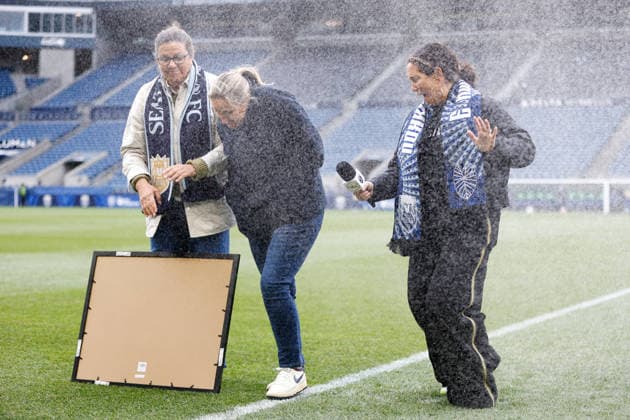 SEATTLE, WA - MAY 15: Head coach Laura Harvey of the Seattle Reign is sprayed by a sprinkler during her 300 game celebration before a game between Gotham FC and the Seattle Reign on May 15, 2026 at Lumen Field in Seattle, Washington. (Photo by Henry Rodenburg Icon Sportswire) SOCCER: MAY 15 NWSL Seattle Reign FC vs Gotham FC EDITORIAL USE ONLY Icon26051502