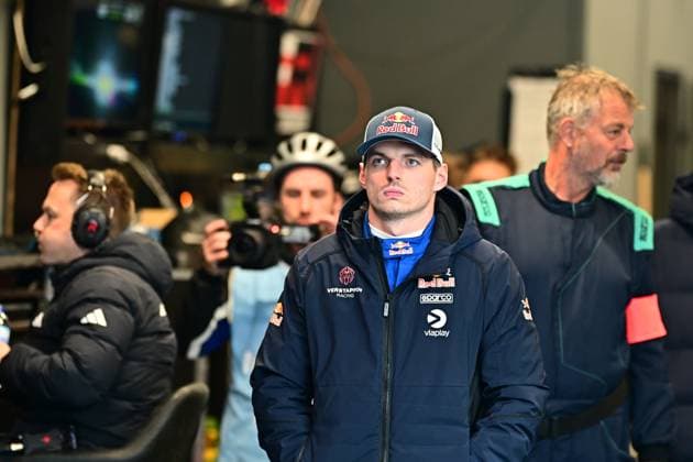Max Verstappen stands concentrated in the pits or in the paddock at the Nürburgring He wears a Red Bull cap and a jacket with the logos of Verstappen Racing, Red Bull, Sparco and Viaplay Team members, a cameraman and monitors can be seen in the background Max Verstappen in the paddock at the 24h Nürburgring 2026 Copyright: xMichaelxGelhardtx