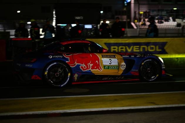 The Daniel Juncadella Jules Gounon Lucas Auer Max Verstappen Mercedes AMG Team Verstappen Racing from Mercedes AMG Team Verstappen Racing drives through the pit lane at the Nürburgring in the dark The vehicle wears the characteristic Red Bull design in blue and red with the striking bull logo on the flank Sponsors such as RAVENOL, Viaplay and Sparco are clearly recognizable In the background, the RAVENOL banner shines in rich yellow Mercedes AMG GT3 3 from Verstappen Racing at night at the Nürburgring Copyright: xMichaelxGelhardtx