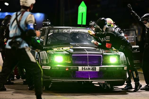 The Hofor Racing by Bonk Motorsport vehicle completes a night-time pit stop in the Nürburgring pit lane The mechanics clean the windscreen and look after the dark green painted vehicle, whose striking green and purple lighting emphasizes the nocturnal atmosphere Clearly visible sponsors are H R, Wempe, Hankook, Kärcher and Parkside The pit lane sign with the number 132 is attached to the side of the vehicle Night-time pit stop at the Nürburgring 24h - Hofor Racing 189 Copyright: xMichaelxGelhardtx