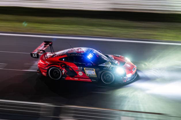 The Porsche 911 GT3 R 992 Evo26 with starting number 18 from the Lionspeed GP team with drivers Kyle Tilley, Jake Hill and Patrick Kolb drives at night on the Nürburgring Grand Prix circuit in Nürburg, Rhineland-Palatinate, Germany during the 24-hour race.