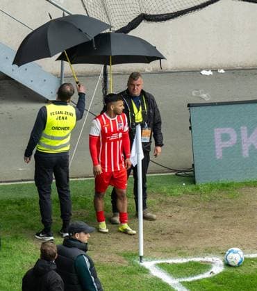 FOOTBALL REGIONAL LEAGUE NORTH-EAST 34 GAME DAY FC CARL ZEISS JENA FC ROT WEISS ERFURT FOR EDITORIAL PURPOSES ONLY p 16 05 2026 Jena Football Regionalliga Nordost 34 Matchday Season 2025 2026 Ernst Abbe Sportfeld FC Carl Zeiss Jena FC Rot Weiss Erfurt in photo Sejdo Durakov 54 FC RotWeiß Erfurt is protected by stewards with umbrellas at the corner kick Germany Thueringen Jena Copyright SaschaxFromm Copyright: SaschaxFromm doc85vo77mpncnljikx1e52 ,EDITORIAL USE ONLY Copyright: SaschaxFromm