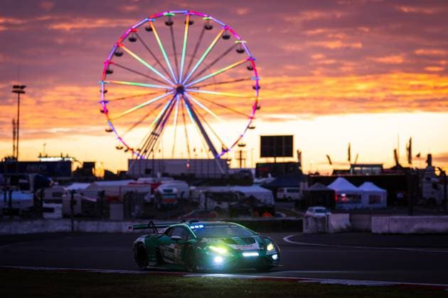 The Lamborghini Huracán GT3 Marco Mapelli Nicholas Yelloly Nicky Catsburg Red Bull Team ABT by Red Bull Team ABT drives around the Nürburgring circuit in the twilight The switched-on headlights shine brightly, while in the background a colorfully illuminated Ferris wheel shines against a spectacular orange sunset sky The atmosphere conveys the special mood of the 24-hour race at the transition from day to night Lamborghini 130 by Red Bull Team ABT at sunset at the Nürburgring Copyright: xMichaelxGelhardtx