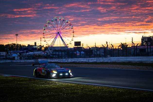 The Mercedes AMG GT3 Daniel Juncadella Jules Gounon Lucas Auer Max Verstappen Mercedes AMG Team Verstappen Racing from Mercedes AMG Team Verstappen Racing drives through the Nürburgring at dusk The switched-on headlights illuminate the track, while a dramatic red-orange sunset colors the sky In the background, the illuminated Ferris wheel of the festival grounds turns, underlining the special atmosphere of the 24-hour race The Red Bull livery of the vehicle is clearly visible in the last light of day Mercedes AMG GT3 3 by Verstappen Racing at sunset at the Nürburgring Copyright: xMichaelxGelhardtx