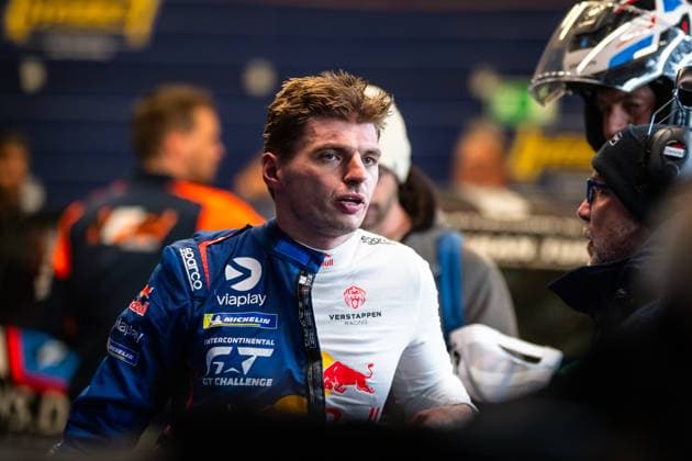 Max Verstappen can be seen talking in the Nürburgring paddock He is wearing the blue racing overall of Mercedes AMG Team Verstappen Racing with sponsors such as Viaplay, Michelin, Red Bull and Sparco as well as the Intercontinental GT Challenge logo In the background, other people and team vehicles can be seen out of focus Max Verstappen talking at the 24h Nürburgring 2026 Copyright: xMichaelxGelhardtx