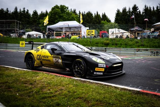 Christian Krognes Mattia Drudi Nicki Thiim Felipe Fernandez Laser natural elements by Walkenhorst Motorsport from natural elements by Walkenhorst Motorsport drives through a corner on the Nordschleife of the Nürburgring The black and yellow car carries the starting number 34 and is equipped with sponsors such as RAVENOL and Pirelli tires Spectators and tents of the paddock can be seen in the background, while the wet weather makes the track challenging Aston Martin GT3 34 from natural elements by Walkenhorst Motorsport at the Nürburgring Copyright: xMichaelxGelhardtx