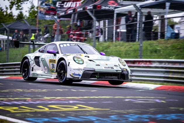 The Porsche 911 GT3 R Laurens Vanthoor Laurin Heinrich Ricardo Feller Lionspeed GP from Lionspeed GP takes a corner on the Nordschleife of the Nürburgring The white and green car with the starting number 24 is decorated with sponsors such as RAVENOL, H R and Michelin Spectators can be seen in the background behind the safety fence Porsche 911 GT3 R 24 from Manthey on the Nordschleife Copyright: xMichaelxGelhardtx