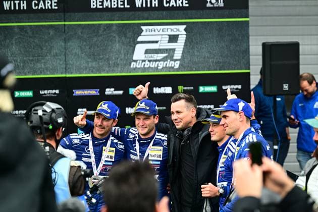The drivers of Mercedes AMG Team RAVENOL proudly present their trophy after winning the 24h Nürburgring The crew in blue team clothing with RAVENOL and H R sponsoring shows thumbs up in front of the podium with Nürburgring branding Mercedes AMG Team RAVENOL 80 celebrates victory at 24h Nürburgring Copyright: xMichaelxGelhardtx