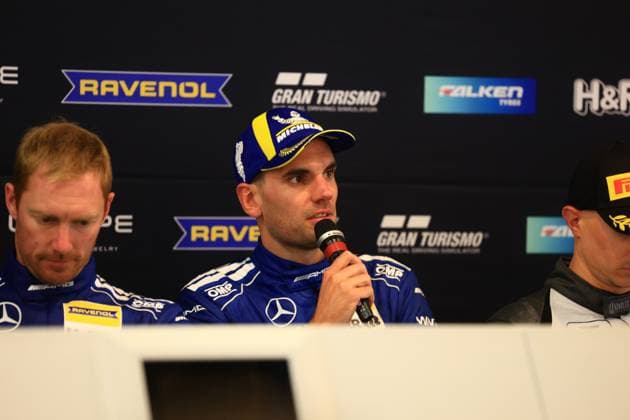 Luca Stolz and Maxime Martin from Mercedes AMG Team RAVENOL present themselves at a press conference The drivers in the characteristic blue Mercedes AMG overalls sit on the podium with microphones in front of sponsor advertising Mercedes AMG Team RAVENOL 80 at the press conference for the 24h Nürburgring Copyright: xspeedshotx