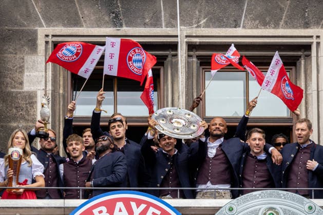 Fußball: Meisterfeier des FC Bayern München auf dem Rathausbalkon und am Marienplatz in München nach dem Gewinn der Bundesliga-Saison 2025 2026. Jubel auf dem Balkon mit Meisterschale, Die Mannschaft mit Trainer Vincent Kompany