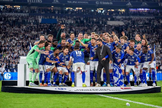 17 05 2026, Football, FC Schalke 04 Eintracht Braunschweig, Matchday 34, Bundesliga 2, Veltins Arena Gelsenkirchen, Season 2025 2026 Schalke 04 is champion of the 2 Bundesliga The team wins the championship and stands cheering on the pitch Joy and emotions after the victory Handover ceremony Kenan Karaman Schalke04 19 with the championship trophy in his hand next to head coach Miron Muslic Schalke04 on the podium DFB regulations prohibit any use of photographs as image sequences and or quasi video North Rhine-Westphalia Germany