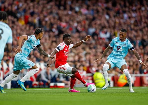 Bukayo Saka of Arsenal is challenged by Lucas Pires (left) and Jaidon Anthony of Burnley Arsenal v Burnley, Football, Premier League, Emirates Stadium, Islington, London, UK - 18 05 2026 EDITORIAL USE ONLY No use with unauthorised audio, video, data, fixture lists, club league logos or live services. Online in-match use limited to 120 images, no video emulation. No use in betting, games or single club league player publications.  Copyright: xMattxImpey Shutterstockx 16882378t
