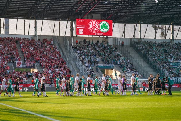 Germany Football 2 Bundesliga Relegation 2025 2026 Rot Weiss Essen vs SpVgg Greuther Fürth Stadion an der Hafenstraße Essen Teams of Rot Weiss Essen and SpVgg Greuther Fürth enter the pitch together with children in front of a sold-out stadium View of home and guest fans and video cubes with relegation branding Football fans, choreography, traditional clubs, promotion fight, 2 Bundesliga, matchday, stadium atmosphere, home block, guest block, soccer culture, Ruhr area, North Rhine-Westphalia, sporting event, German Football League, stadium architecture, evening sun, STEINSIEK CH Copyright: xJOERANxSTEINSIEKx