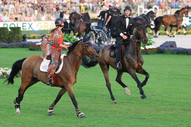 Richard Vogel and Luciana Diniz together in Bond Stunt Feeling over the obstacles, concert horse symphony, supporting program, motto of the evening James Bond, World Equestrian Festival, TSCHIO Aachen 2026, TSCHIO instead of CHIO 2026, Aachener Soers, 22 to 24 May 2026, equestrian sport, 23 05 2026, Aachener Soers Germany