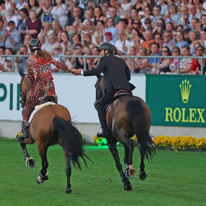 Richard Vogel and Luciana Diniz together in Bond Stunt Feeling over the obstacles, concert horse symphony, supporting program, motto of the evening James Bond, World Equestrian Festival, TSCHIO Aachen 2026, TSCHIO instead of CHIO 2026, Aachener Soers, 22 to 24 May 2026, equestrian sport, 23 05 2026, Aachener Soers Germany