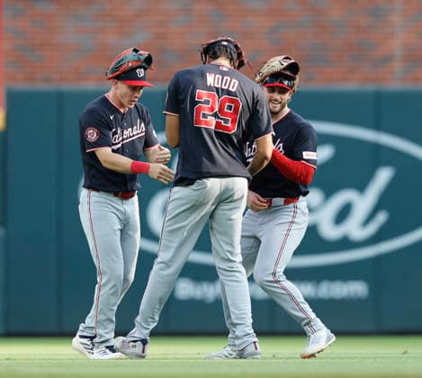 Left fielder Dayton Lile 4 (left), centerfielder Dylan Crews 3 (right) and right fielder James Wood 29 of the Washington Nationals celebrate after the last out of the game against the Atlanta Braves at Truist Park on Saturday, May 23, 2026 in Atlanta, Georgia.  ATL20260523126 MikexZarrilli