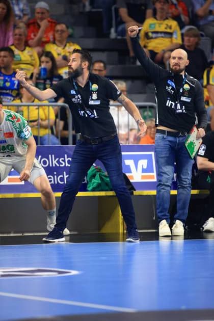SC Magdeburg coach Bennet Wiegert gesticulates passionately on the touchline during the DAIKIN HBL match against Rhein Neckar Löwen in the SAP Arena Next to him is another member of the coaching staff with a tactics board Bennet Wiegert SC Magdeburg cheers on his team in the SAP Arena Copyright: xspeedshotx
