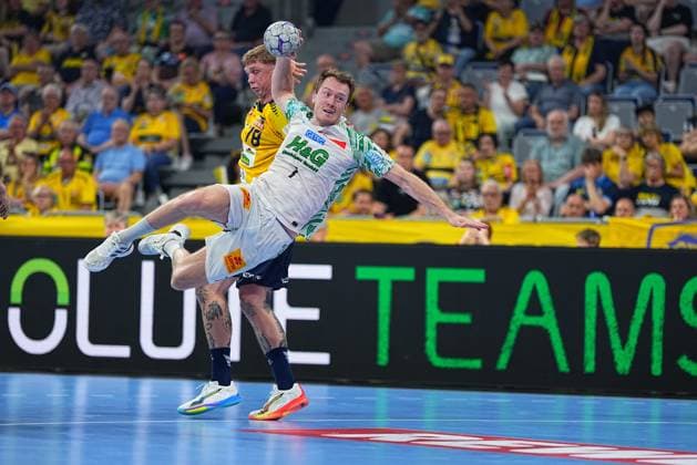 Felix Claar 7, SC Magdeburg in white SCM jersey takes the shot while a Löwen player in yellow jersey 78 tries to block him The duel takes place in front of a sold-out crowd in the SAP Arena Felix Claar SC Magdeburg taking the shot against Rhein Neckar Löwen in the SAP Arena Copyright: xspeedshotx