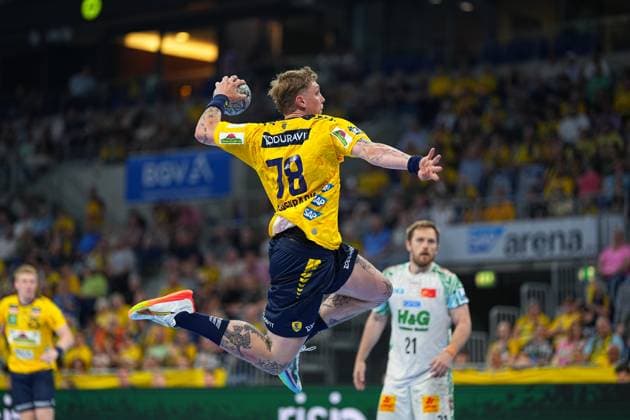 Edwin Aspenbäck 78 Rhein Neckar Löwen jumps in yellow and blue jersey and takes the ball for a shot In the background is Albin Lagergren 21 SC Magdeburg in white jersey Edwin Aspenbäck 78 Rhein Neckar Löwen taking a jump shot in the SAP Arena Copyright: xspeedshotx