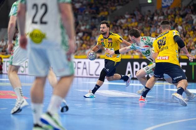 Dani Baijens 77 Rhein Neckar Löwen carries the ball in the back and looks for a passing lane, while a Magdeburg defender white jersey, 22 stands nearby On the right of the picture is Jannik Kohlbacher 80 Rhein Neckar Löwen Dani Baijens 77 Rhein Neckar Löwen in attack against SC Magdeburg Copyright: xspeedshotx