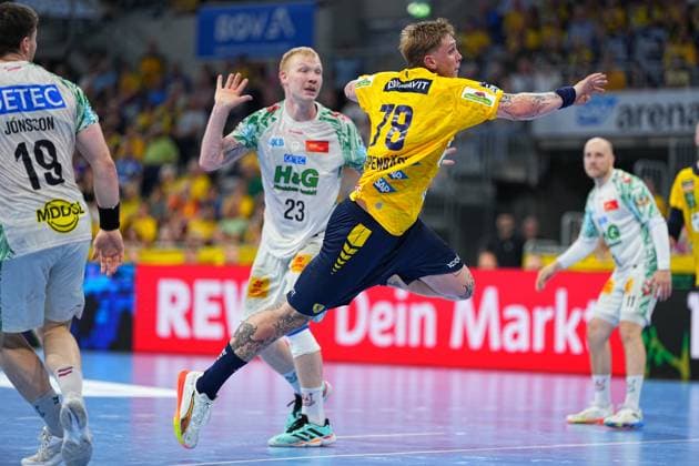 Edwin Aspenbäck 78 Rhein Neckar Löwen jumps for a shot in a yellow and blue jersey, surrounded by SC Magdeburg players in white jerseys, including Magnus Saugstrup 23 and Elvar Örn Jonsson 19 The scene takes place in the packed SAP Arena as part of the DAIKIN HBL Edwin Aspenbäck 78 Rhein Neckar Löwen taking a jump shot in the SAP Arena Copyright: xspeedshotx