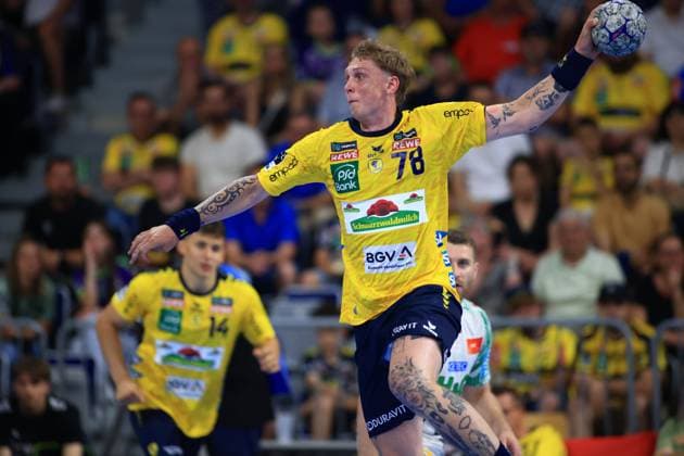 Edwin Aspenbäck 78 of the Rhein Neckar Löwen jumps up to throw in the SAP Arena and holds the ball with his right hand In the background is teammate Gino Steenaerts 14 in yellow jersey Edwin Aspenbäck 78 Rhein Neckar Löwen attempting a throw Copyright: xspeedshotx