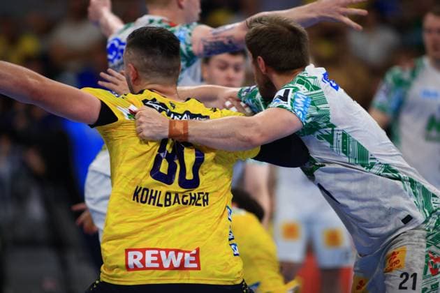 Jannik Kohlbacher 80 Rhein Neckar Löwen in the yellow jersey braces himself against Albin Lagergren 21 SC Magdeburg in the white jersey in the circle runner duel Both players fight intensively for supremacy in the SAP Arena Jannik Kohlbacher 80 Rhein Neckar Löwen in a duel against Albin Lagergren 21 SC Magdeburg Copyright: xspeedshotx