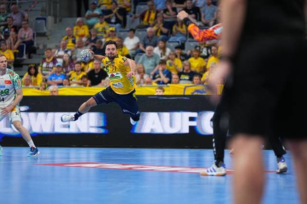 Dani Baijens 77 Rhein Neckar Löwen jumps and takes a shot on goal, while Omar Ingi Magnusson 14 SC Magdeburg is positioned in the background as a defender In the background, numerous spectators watch the game in the packed SAP Arena Dani Baijens 77 Rhein Neckar Löwen taking a jump shot in the SAP Arena Copyright: xspeedshotx