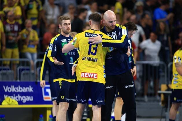 Goalkeeper Mike Jensen 20 Rhein Neckar Löwen hugs Sebastian Heymann 13 after the game in the SAP Arena, while Tim Nothdurft stands in the background All three wear the yellow and blue colors of the Rhein Neckar Löwen Mike Jensen 20 Rhein Neckar Löwen hugs Sebastian Heymann 13 in the SAP Arena Copyright: xspeedshotx